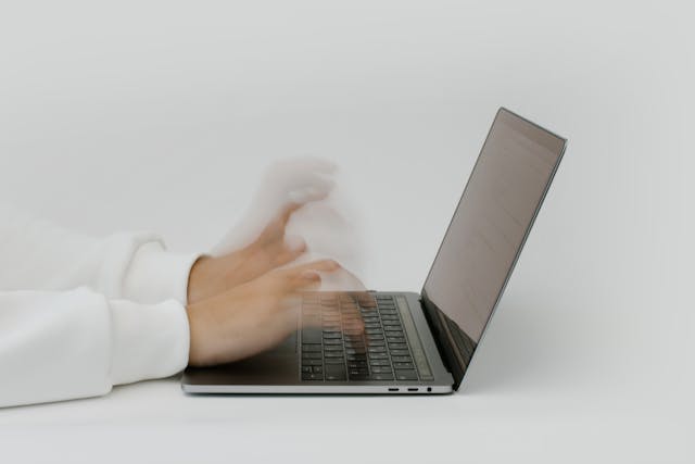 Hands typing fast on a laptop - AI for Productivity